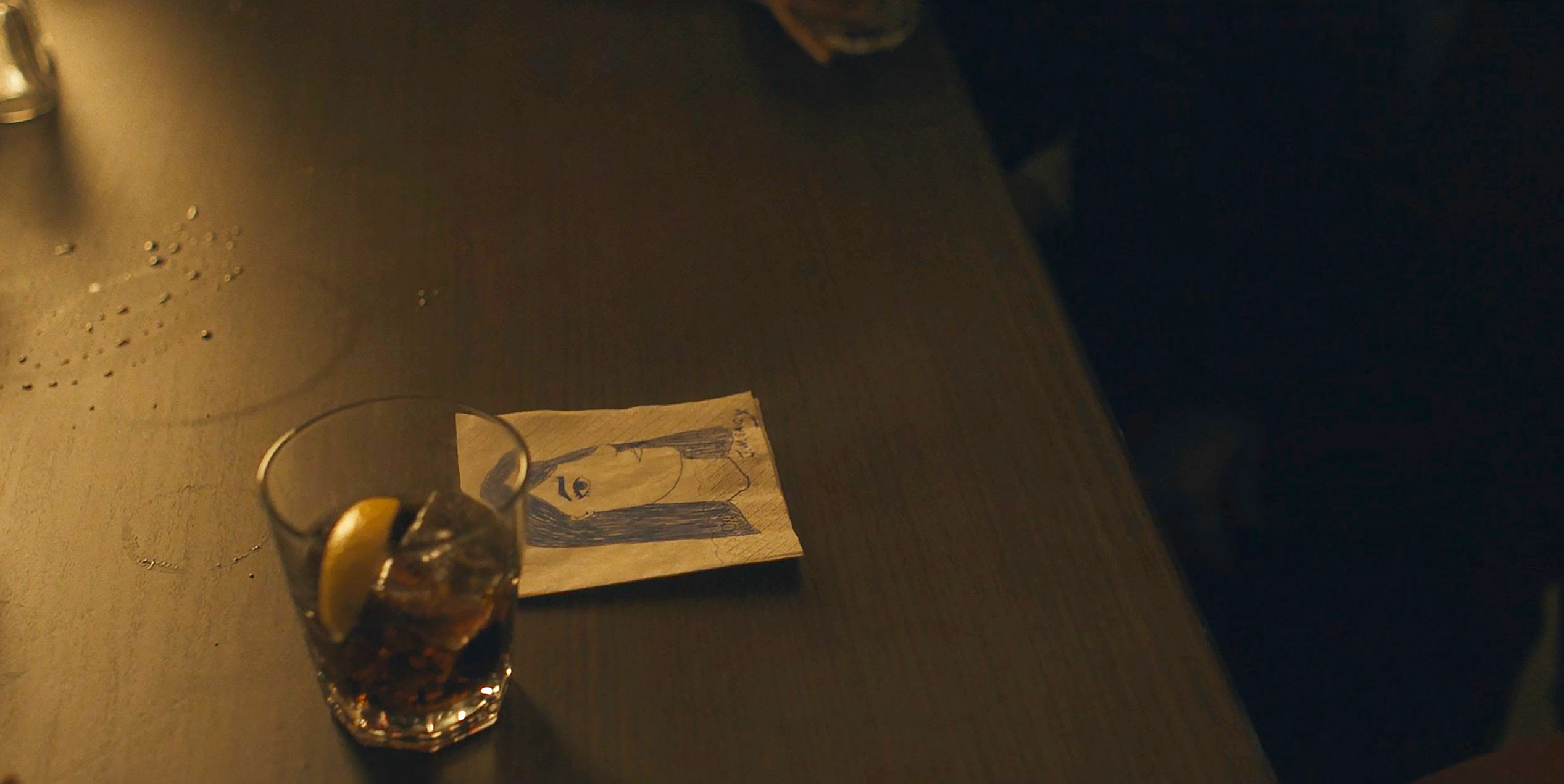 Hand-drawn JWG-style portrait on a cocktail napkin at a bar in Devil in Disguise E4