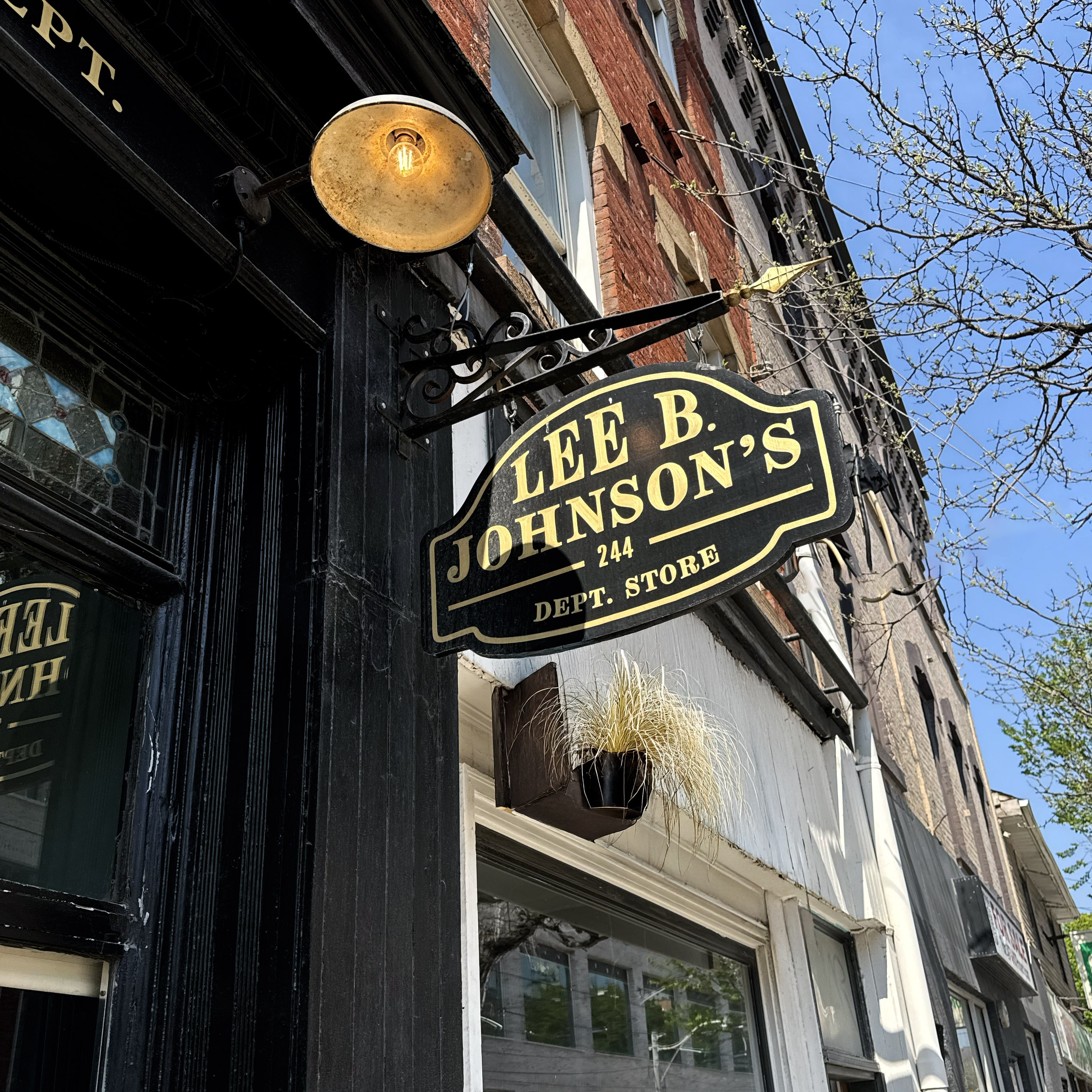 Lee B Johnson's hanging sign with wrought-iron bracket and vintage exterior lamp