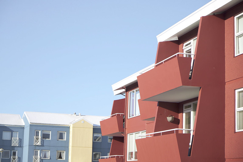 Bold red apartment building with stacked balconies in Reykjavik