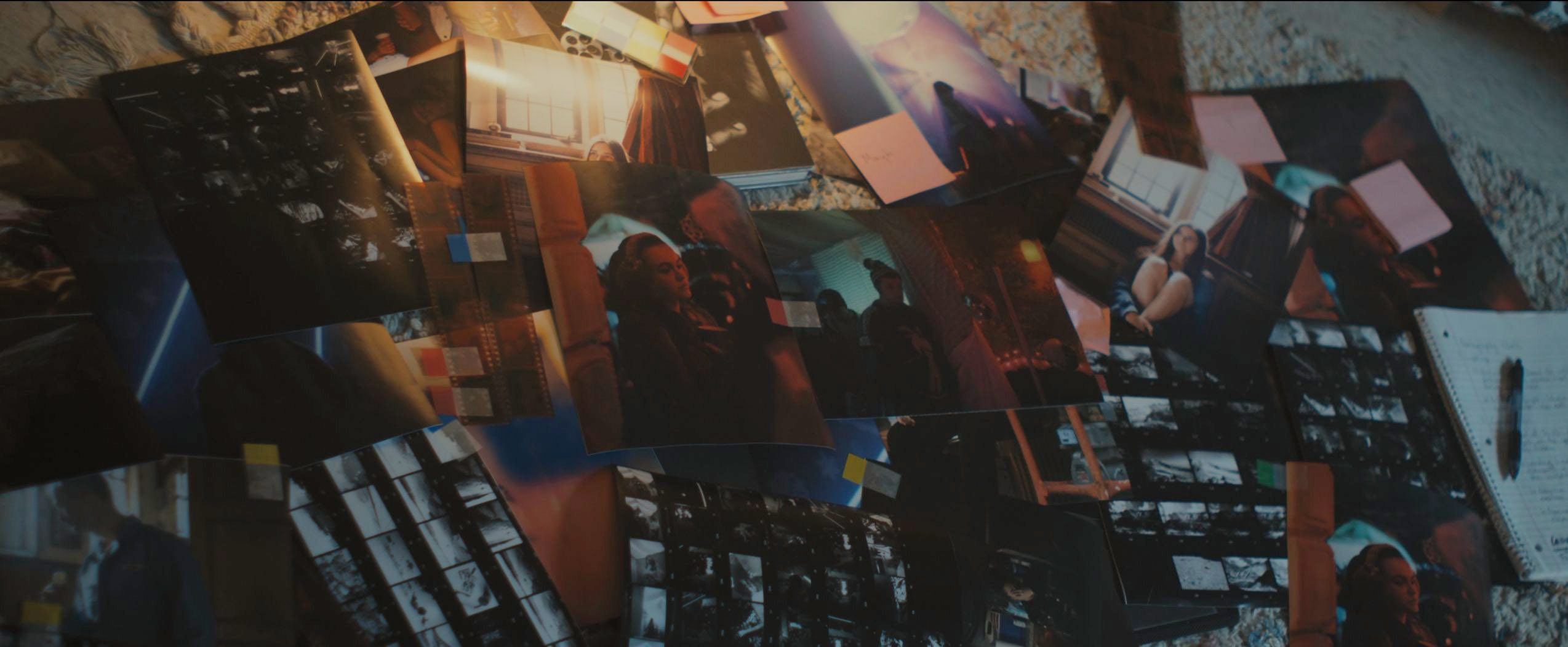 Scattered photographs and negative film strips on a bed in Tell Me Lies S3 E4